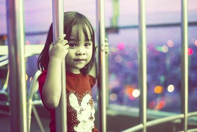 Portrait of cute girl looking through railing