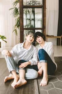 Happy friends sitting on floor at home