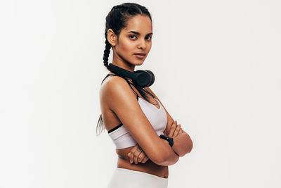 Portrait of young woman sitting against white background