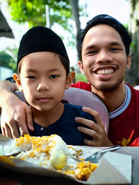 Portrait of smiling boy with ice cream on table