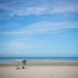 Scenic view of beach with one person against sky