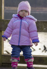 Cute baby girl wearing warm clothing standing outdoors