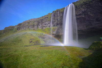 Scenic view of waterfall against sky