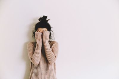 Young woman standing against white background