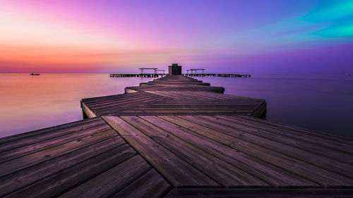 Pier over sea against sky during sunset