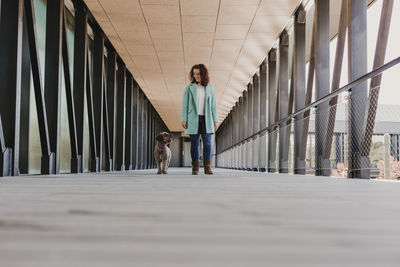 Woman with dog walking on zebra crossing