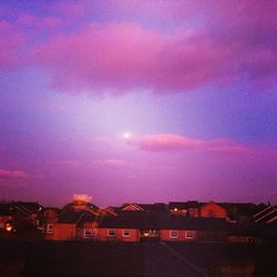 Silhouette of house against cloudy sky at sunset