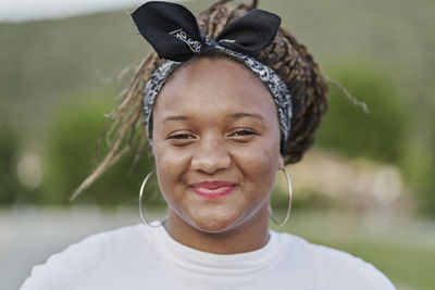 Portrait of a black girl with a hair band holding her dreadlocks