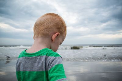 Midsection of young boy standing on beach