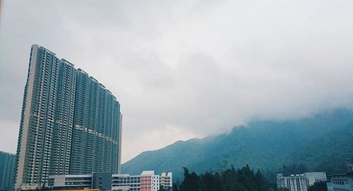 Buildings against cloudy sky