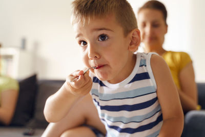 Close-up of boy sitting at home