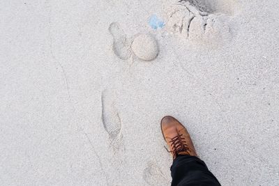 Low section of man standing on sand