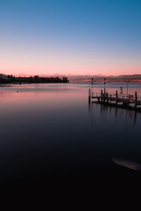 Scenic view of lake against clear sky during sunset