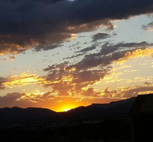 Scenic view of silhouette mountains against dramatic sky