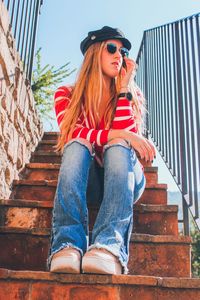 Low angle view of young woman sitting on staircase