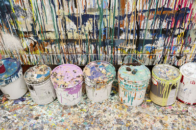 High angle view of dirty paint cans at art studio