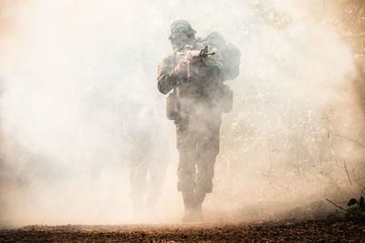 Army soldier shooting with rifle during foggy weather