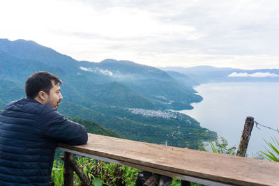 Man looking at mountains against sky