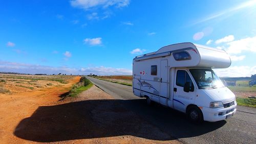 Road amidst landscape against blue sky