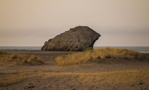 Rock formation on beach in cabo de gata nature park, almeria, spain, against sky during sunrise