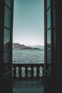 Scenic view of sea against clear sky seen through window