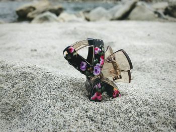 Close-up of abandoned shoes on sand