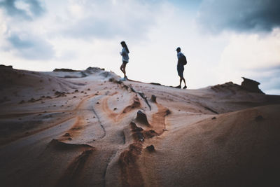 People walking on sand dune