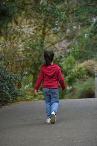 Rear view of woman walking on road