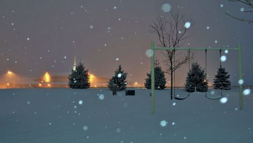 Scenic view of snow covered playground at night