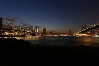 Suspension bridge over river at dusk