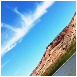 Low angle view of mountain against blue sky