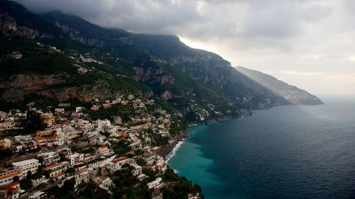 Aerial view of sea and mountains against sky