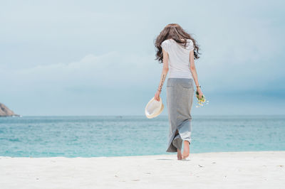 Full length of woman on beach against sky