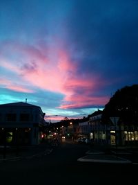 Illuminated buildings against sky at dusk