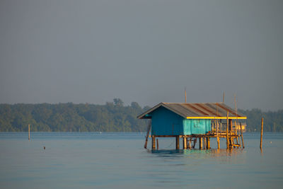 House by lake against clear sky