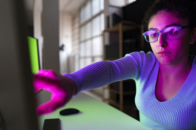 Businesswoman touching desktop screen at home office