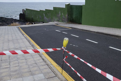 High angle view of arrow symbol on road by sea