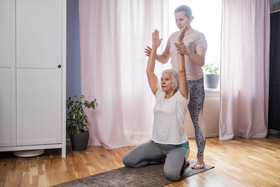 Full length of woman exercising at home