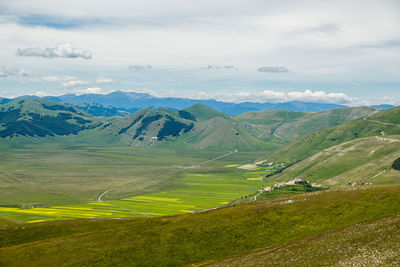 Scenic view of landscape and mountains against sky in castelluccio, umbria 