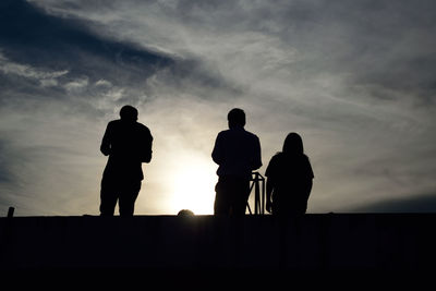 Silhouette people standing against sky during sunset