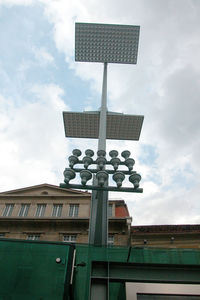 Low angle view of street light by building against sky