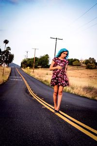 Rear view of woman walking on road