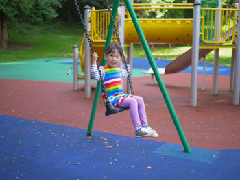 Girl playing on swing in park