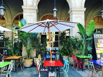 Parasols over colorful empty chairs and table at sidewalk cafe