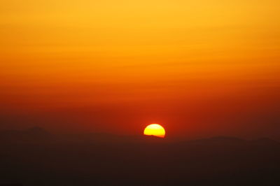 Scenic view of silhouette mountain against orange sky