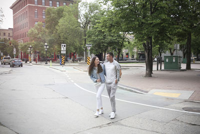 Rear view of woman walking on road in city