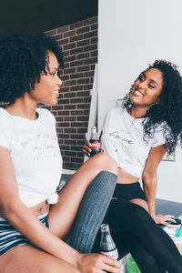 Two black women drinking coca cola in their kitchen