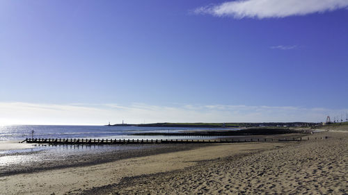 Scenic view of beach against blue sky