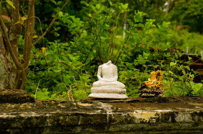 Stack of buddha statue against trees