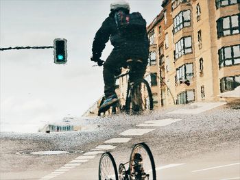 Upside down image of man reflection in puddle while riding bicycle
